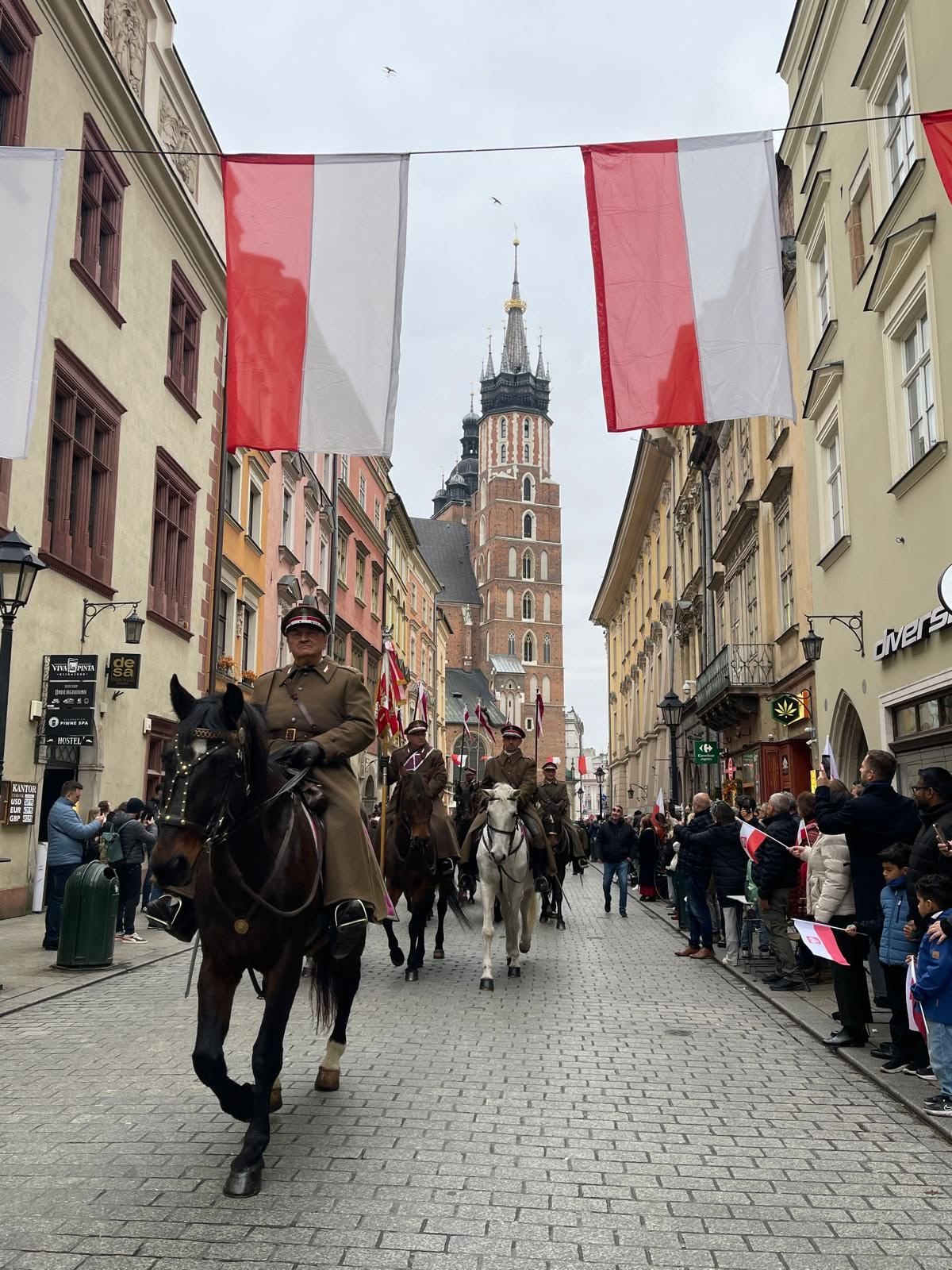 Przemarsz Szwadronu ulicą Floriańską podczas Święta Niepodległości — na czele dowódca, w tle Bazylika Mariacka